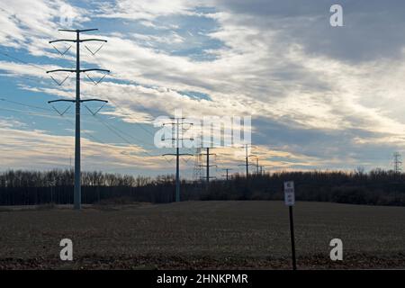 High voltage electrical power towers and cables against a blue sky on a partly cloudy day  -02 Stock Photo