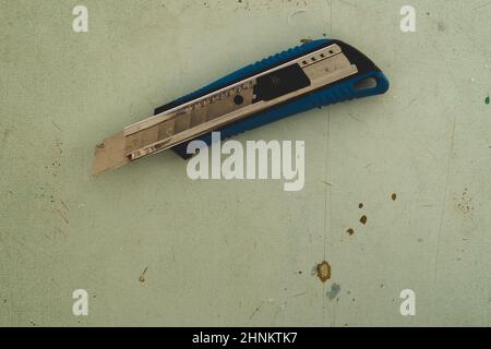 Stationery knife on the wooden floor. cutter knife on the working surface Stock Photo