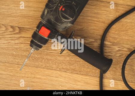 Electric drill on the floor. repair process. work instrument Stock Photo