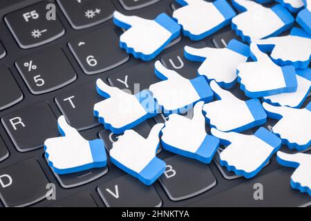Many blue like thumb up icons on computer keyboard. Social media concept Stock Photo