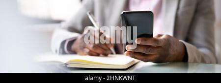 Writing Agenda Week Plan List Using Mobile Phone Stock Photo