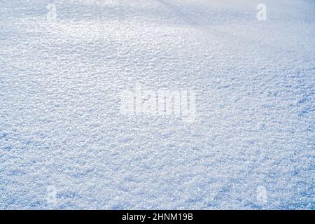 Texture of snow illuminated by sunlight. Winter background. Stock Photo