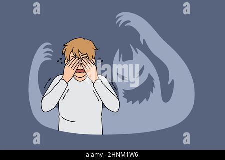 Inner fears and feeling terrified concept. Young stressed frustrated man standing covering eyes with hands feeling chocked and afraid with ghost shado Stock Photo