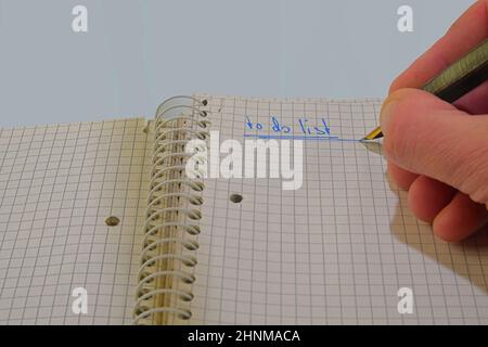 Open notepad with text "to do list". Fountain pen, spiral notebook on table. Business, planning, education concept.  Top view.  Flat lay. Copy space Stock Photo