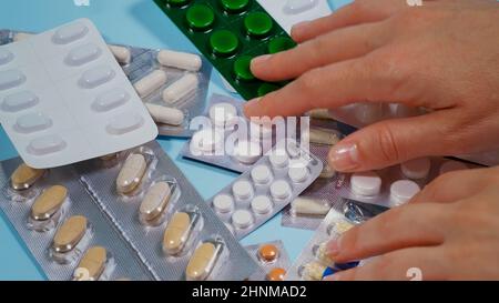 Choose Pill blister. Pharmaceutical medicine pills, tablets and capsules on blue background. Close up. Stock Photo