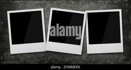 Close up three empty Polaroid instant photo frames on grunge black stone table background, elevated top view, directly above Stock Photo
