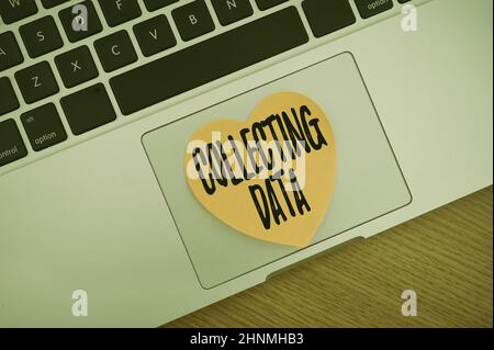 Text sign showing Collecting Data, Business showcase Gathering and measuring information on variables of interest Blank Notepad Laptop With Pen And He Stock Photo