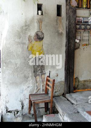 Street art titled Reaching Up by Ernest Zacharevic in Georgetown, Penang, Malaysia Stock Photo