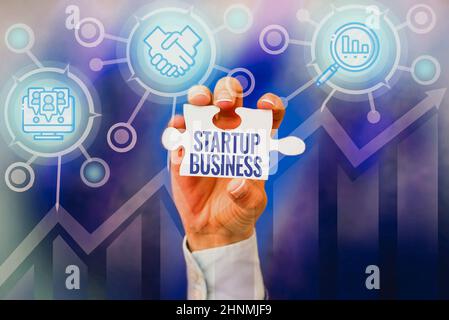 Sign displaying Startup Business, Word Written on Engaging to a New Venture Fresh Trading and Selling Hand Holding Jigsaw Puzzle Piece Unlocking New F Stock Photo