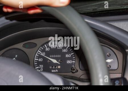 Hand on the handlebars in the car. Speedometer and steering wheel. Stock Photo