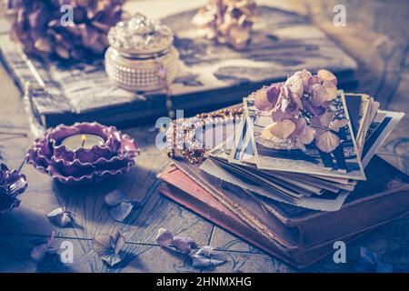 Memories - old family photo album with necklace, old books and dried flowers Stock Photo