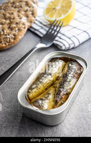 Canned sardines. Sea fish in tin can on kitchen table. Stock Photo