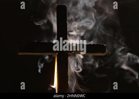 Burning cross with smoke in dark night Stock Photo