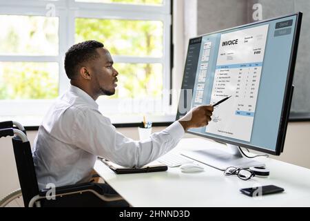 Disabled African Accountant Working On Computer In Wheelchair Stock Photo
