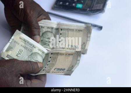 Senior aged Man hand counting Indian rupee note on table. High angle view. Close up. Stock Photo