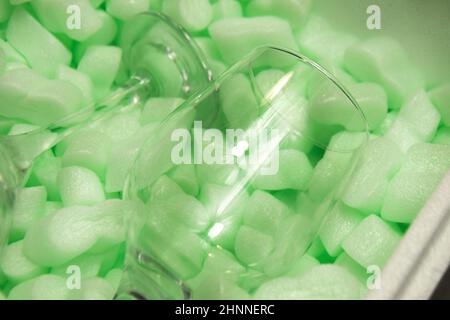 Styrofoam granular packaging filler for parcels, Protective Packaging . Glass protection, sterilized glasses. Green packaging Stock Photo