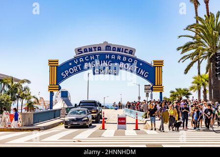 people have fun entering the pier to the amusement area pacific park on the pier of Santa Monica by night. Stock Photo