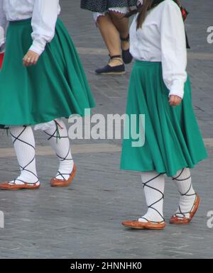 Photo of young girls wearing costume clothes and performing Basque folk dance in the street Stock Photo