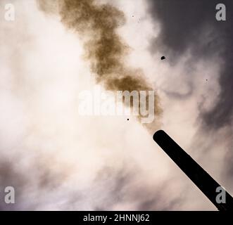 smoke from the chimney on the cloudly sky background colored Stock Photo