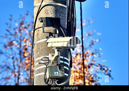a surveillance camera is hanging on a concrete pillar with an infrared flashlight Stock Photo