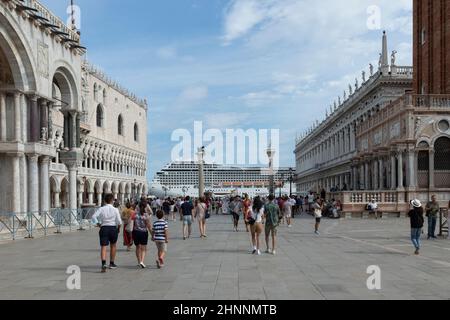 Cruise ship MSC ORCHESTRA in the Venetian lagoon with gondolas and tourists in the foreground in Venice. Venice is a major tourist destination in Italy. Stock Photo