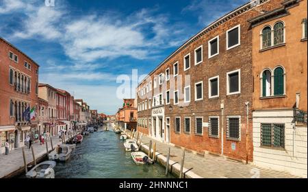 scenic view to island of Murano in Venice area with small canal and historic houses, Murano Stock Photo
