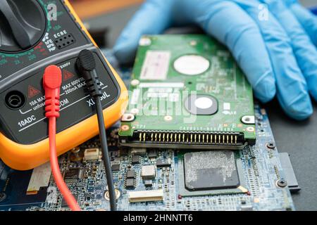technician repairing inside of hard disk by soldering iron. Integrated Circuit. the concept of data, hardware, technician and technology. Stock Photo