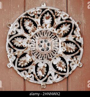 Old rusty peephole-big round flower design-wooden garage door. Tavira-Portugal-108 Stock Photo