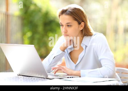 Serious businesswoman working online with laptop in terrace Stock Photo