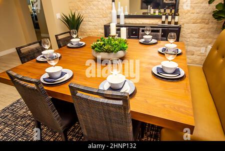 Square Wooden Dining Area Table With Eight Place Settings Stock Photo