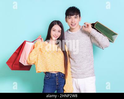 Happy couple with shopping bags.Isolated on blue background. Stock Photo