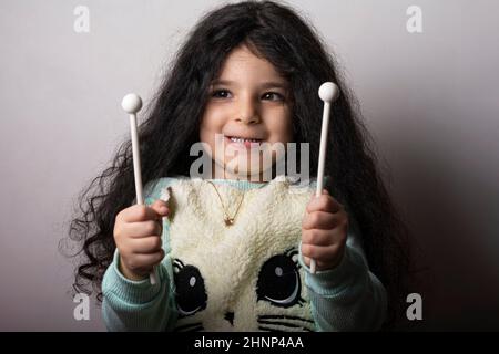 Little girl portrait with xylophone sticks in hands with funny expression Stock Photo