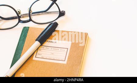 Brown craft paper cover notebook with pen and eyeglasses on desk isolated white background. Stock Photo