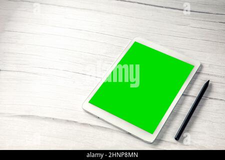 Digital tablet computer with pen and isolated green screen white wooden desk top view, copy space for film,movie, moving image Stock Photo