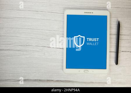 The Netherlands, December 2021 Trust wallet app Crypto Bitcoin Ewallet on digital tablet top view on wooden table, secure payment for cryptocurrency Stock Photo