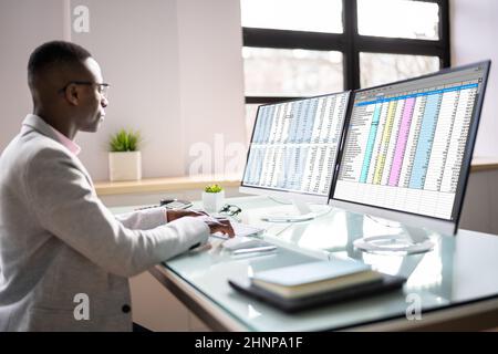 Computer Spreadsheet Data Analyst Man Using Multiple Screens Stock Photo