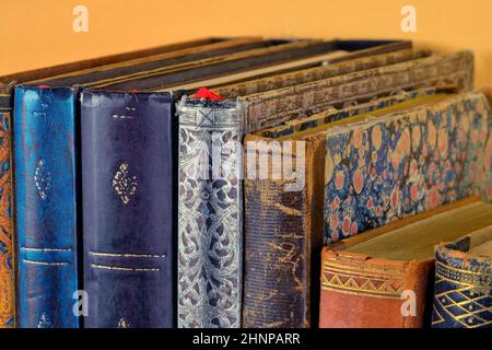 Cultural heritage. Old books on wooden shelf. Antique books on yellow background. Close up Stock Photo