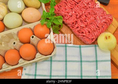 Minced meat, eggs, garlics and onion. Mixed minced meat ready to making burgers, fatty's, meaetballs. Food photography. Culinary concept. Minced meat recipe Stock Photo