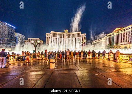 people watch famous Bellagio Hotel with water games in Las Vegas at night Stock Photo