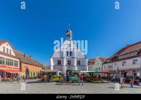 people enjoy gothic St Petri church in Wolgast under blue sky with historic market place Stock Photo