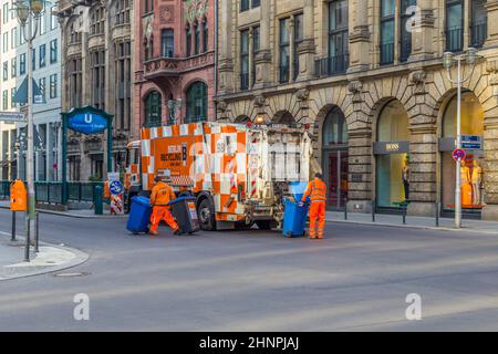 garbage people with the truck collect the garbage bins in Berlin Stock Photo