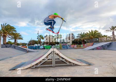 boy jumping at the skate park over a ramp Stock Photo