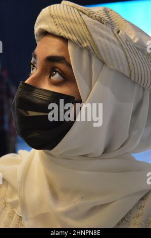 Expo staff member with face mask and traditional costume in The Pakistan Pavilion at Expo 2020 Dubai UAE - February 1, 2022. Stock Photo