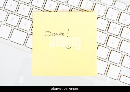 Postit note saying Danke arranged on a laptop keyboard Stock Photo