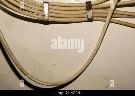 Old electrical wires or cables hanging on the wall. industrial background Stock Photo