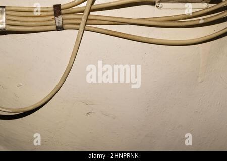 Old electrical wires or cables hanging on the wall. industrial background Stock Photo