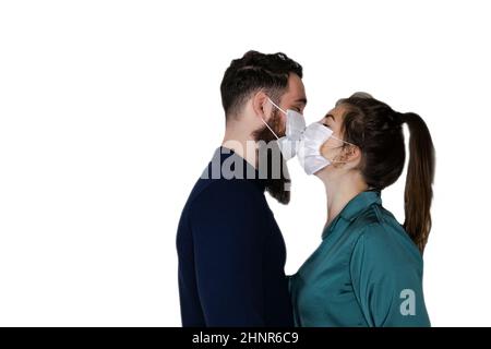 Loving couple kissing each other with protective medical masks on face during Coronavirus outbreak,pandemic, isolated on white background with copy space, Covid-19,health,Valentines Day concept Stock Photo
