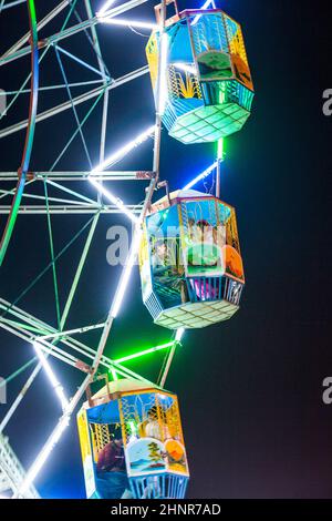 people enjoy the big wheel in the amusement park in Delhi Stock Photo