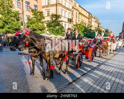 Horse carriages in front of Mariacki church on main square of Krakow Stock Photo