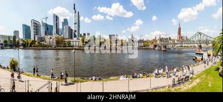 People walk along the river Main with Frankfurt Skyline Stock Photo